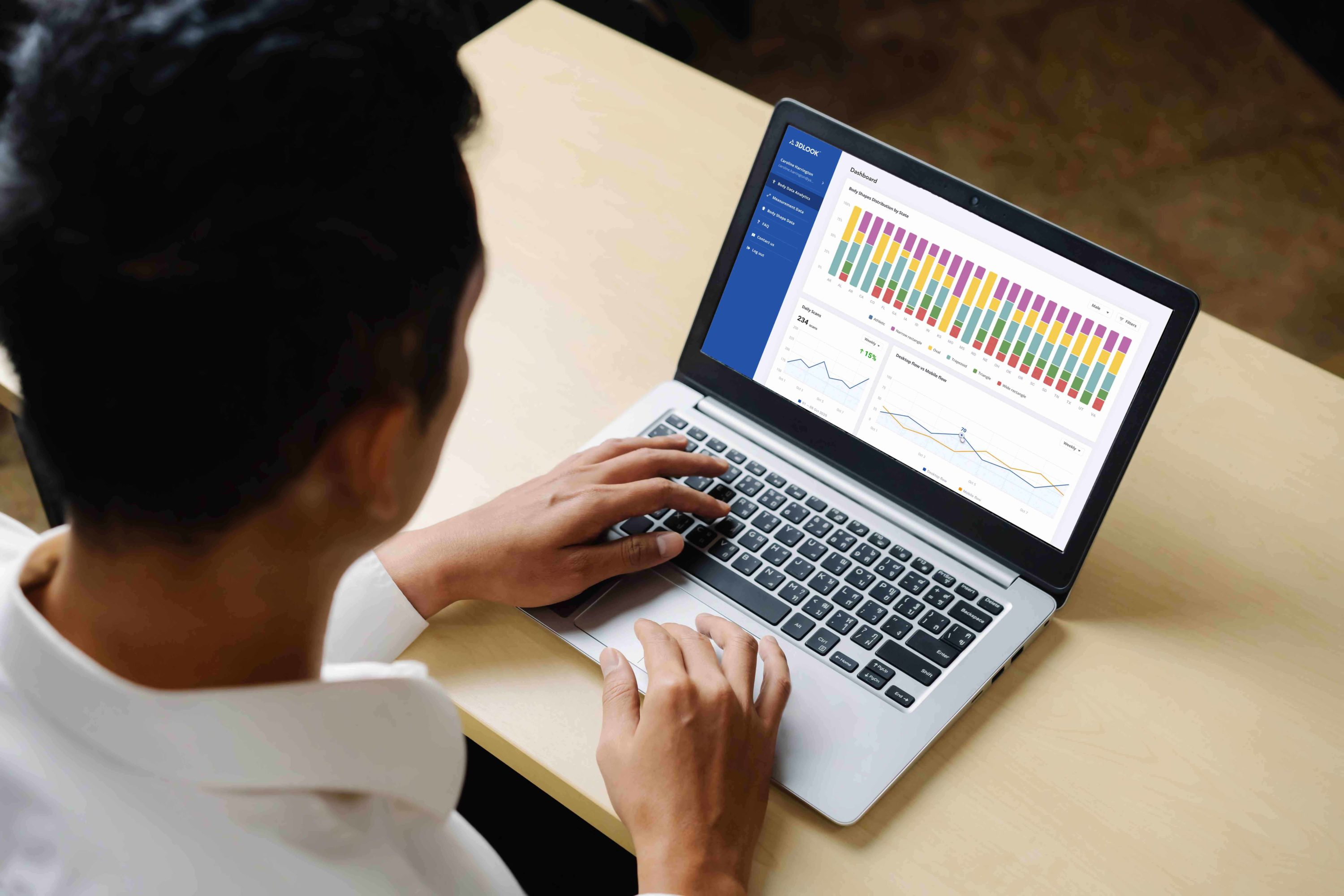 A man using a laptop with analytics graph displayed.