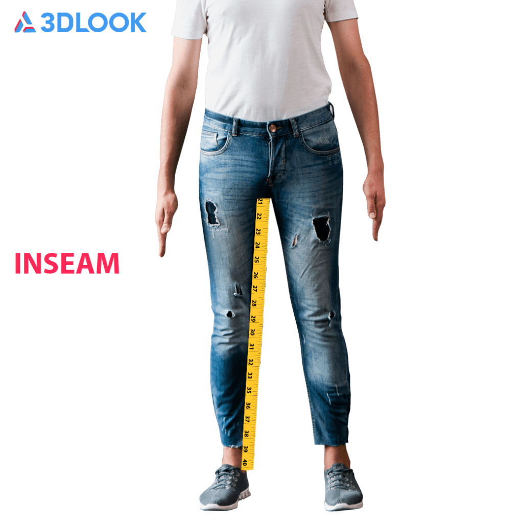 A person standing in jeans and a white shirt with a measuring tape indicating the inseam length of the jeans. The word 