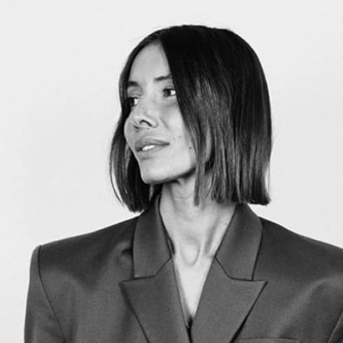 A black and white photo of a woman in a suit showcasing sustainable fashion.