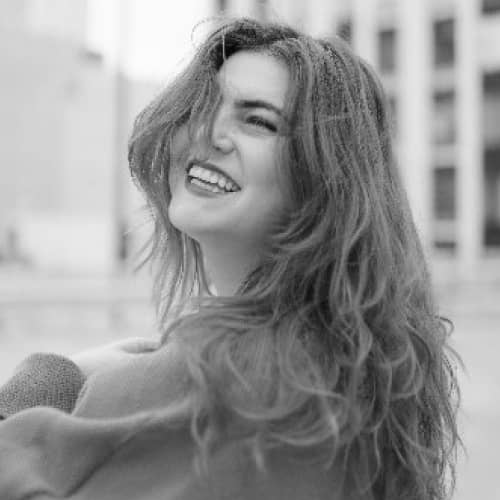 A black and white photo of a woman smiling, perfect for influencers in the sustainable fashion industry.