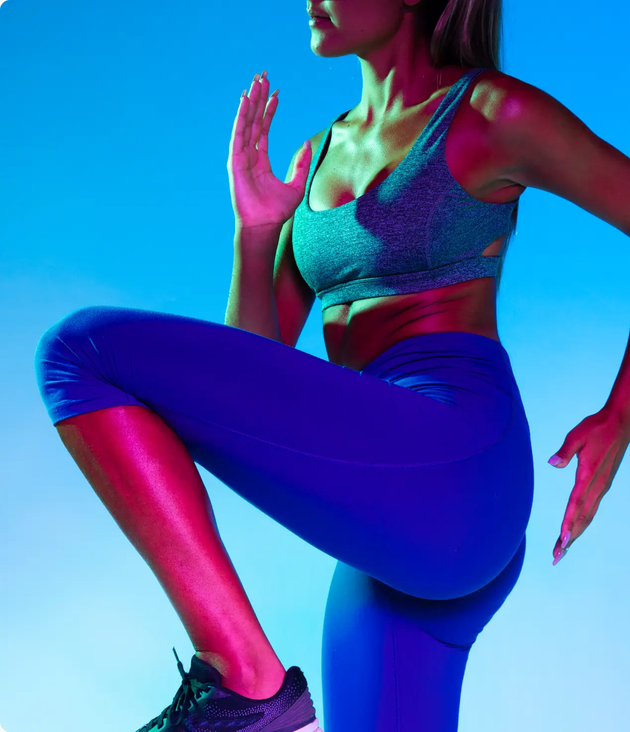 A woman in a blue sports bra doing a squat to improve her fitness.
