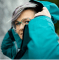 Person in a turquoise jacket adjusting their hair, showcasing the latest in MT Redesign 2024.