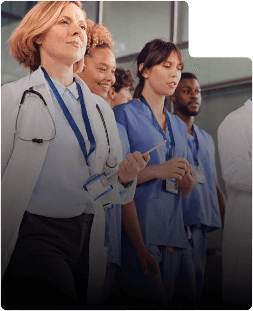 A group of healthcare professionals in medical uniforms, including a doctor and nurses, walking together in a hospital setting, epitomizing the teamwork promoted by FitXpress.